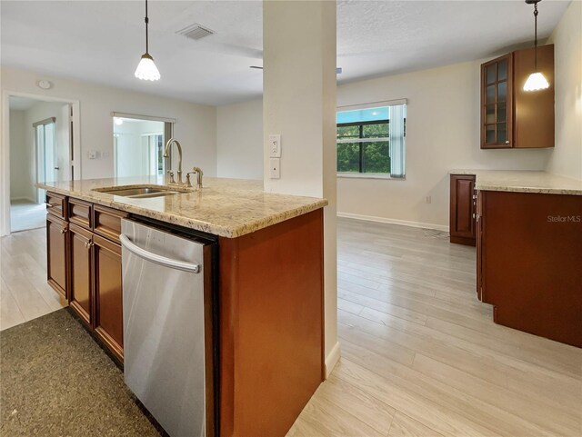 kitchen featuring glass insert cabinets, light stone counters, hanging light fixtures, stainless steel dishwasher, and a sink