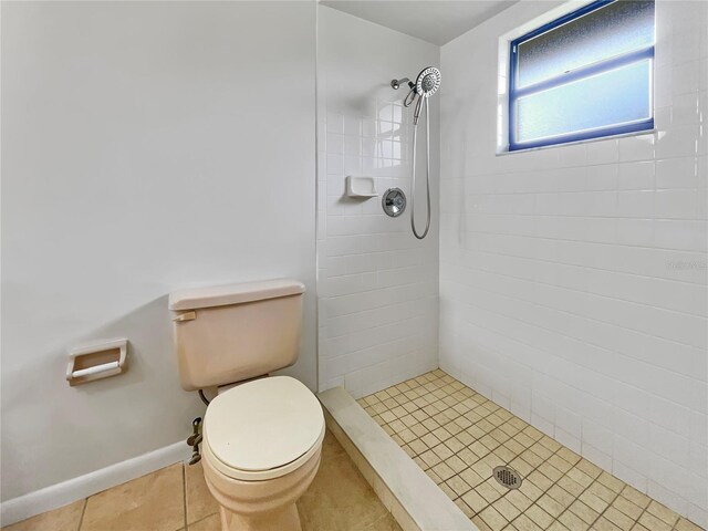 full bath featuring a stall shower, baseboards, tile patterned flooring, and toilet