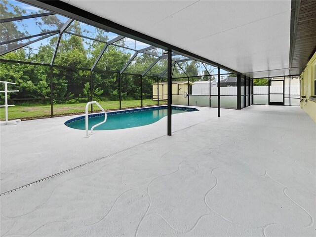 pool featuring glass enclosure, a shed, a patio, and an outdoor structure