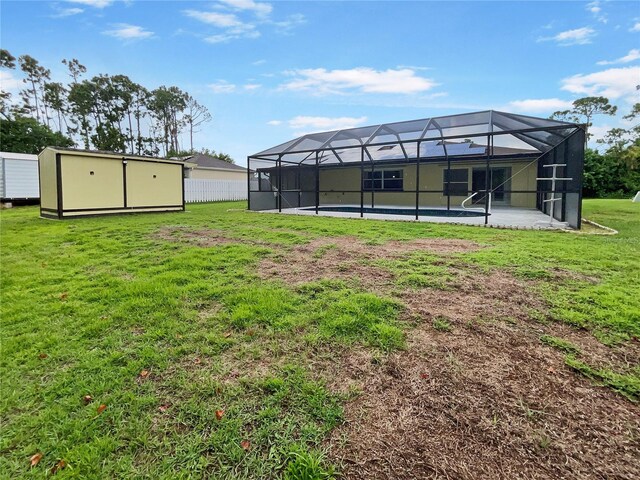 rear view of house featuring a yard, fence, a lanai, and an outdoor pool