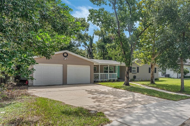 ranch-style home with a garage, driveway, a front yard, and cooling unit