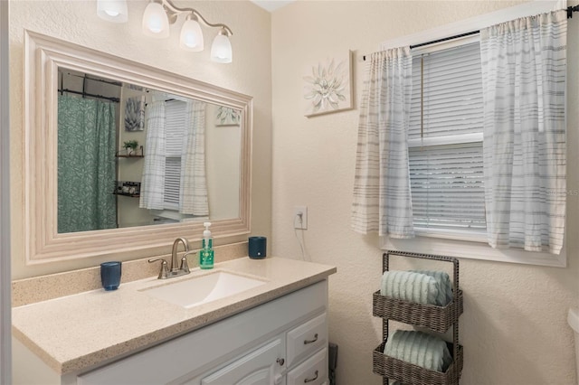 bathroom featuring a textured wall and vanity