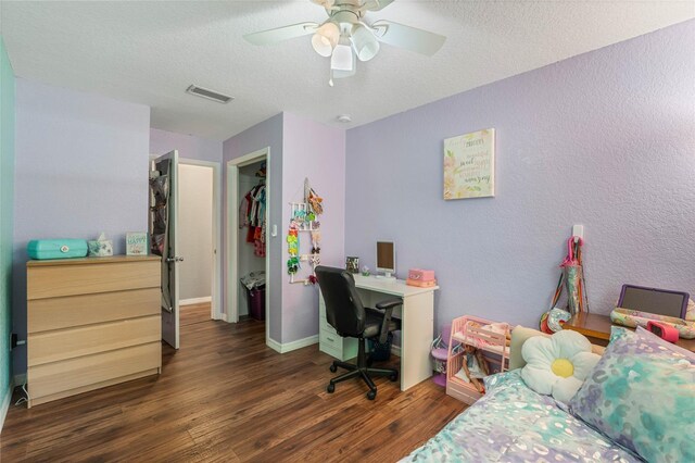 office featuring ceiling fan, a textured ceiling, and dark wood-type flooring