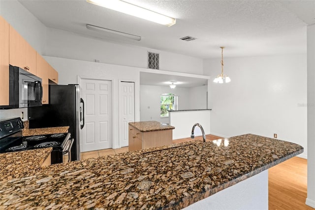 kitchen featuring dark stone counters, light hardwood / wood-style flooring, a textured ceiling, kitchen peninsula, and range with electric cooktop