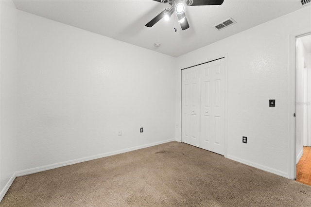 unfurnished bedroom with ceiling fan, a closet, and carpet