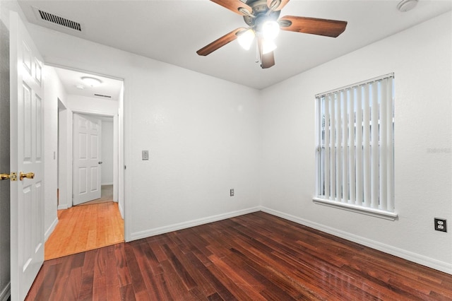 spare room featuring ceiling fan and dark hardwood / wood-style floors