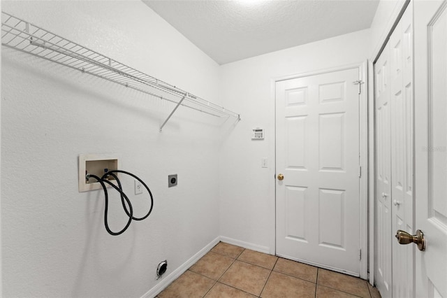 clothes washing area featuring washer hookup, light tile patterned flooring, and electric dryer hookup