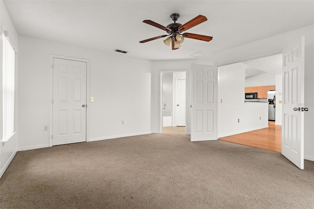 unfurnished room with ceiling fan and light carpet