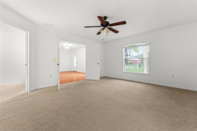 empty room featuring ceiling fan and light carpet