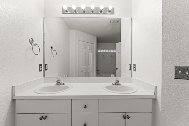 bathroom featuring a textured ceiling and vanity