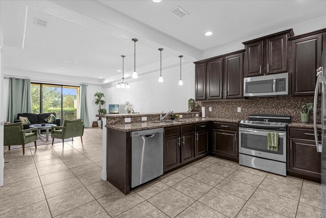 kitchen featuring tasteful backsplash, sink, dark stone countertops, kitchen peninsula, and stainless steel appliances