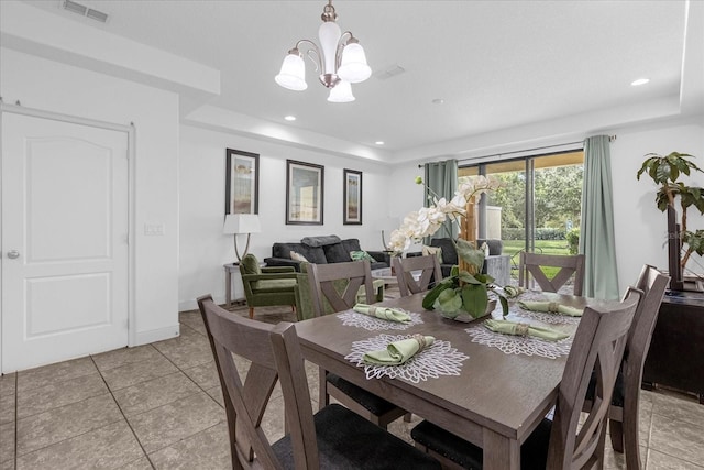 dining room featuring light tile patterned floors, an inviting chandelier, and a tray ceiling