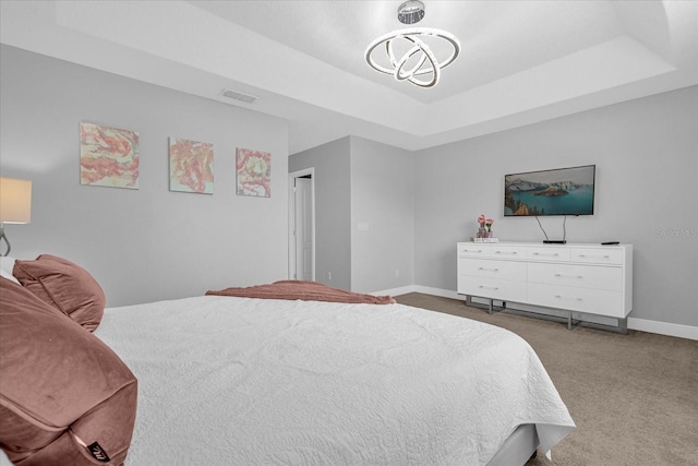 bedroom featuring carpet flooring and a raised ceiling