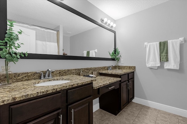 bathroom featuring tile patterned flooring, a textured ceiling, and vanity