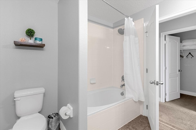 bathroom with shower / bath combo, toilet, a textured ceiling, and tile patterned flooring