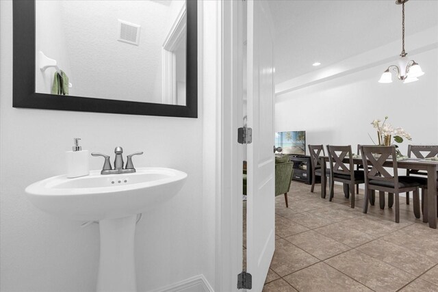 bathroom featuring tile patterned floors and a chandelier