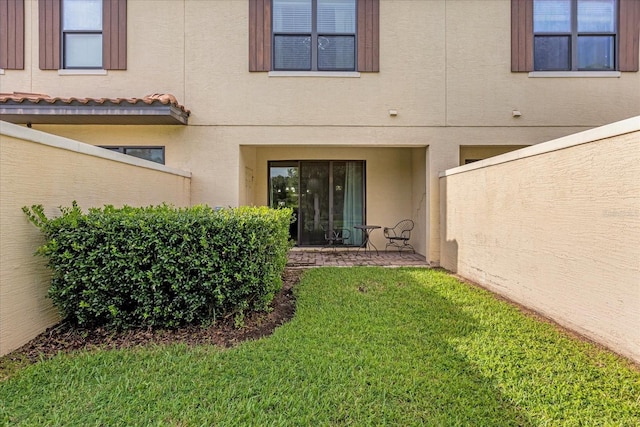 8110 Roseville Rd, Davenport, FL 33896 - entrance to property with stucco siding, a yard, and a tiled roof