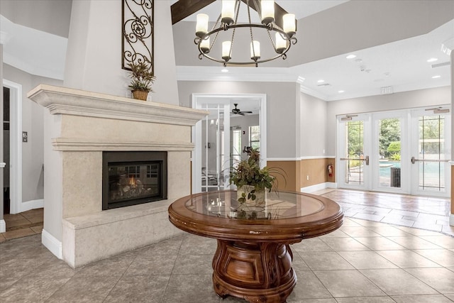 living room with a fireplace, tile patterned flooring, ceiling fan with notable chandelier, and french doors