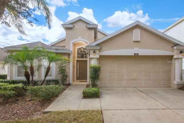 mediterranean / spanish house featuring a garage, driveway, and stucco siding