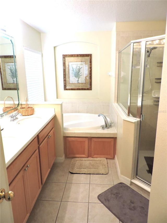 bathroom featuring a shower stall, vanity, a bath, and tile patterned floors