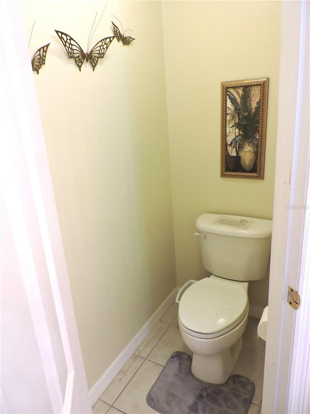 bathroom featuring tile patterned flooring, toilet, and baseboards