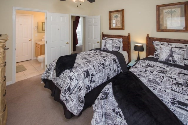 bedroom featuring a ceiling fan, light colored carpet, ensuite bathroom, and light tile patterned floors