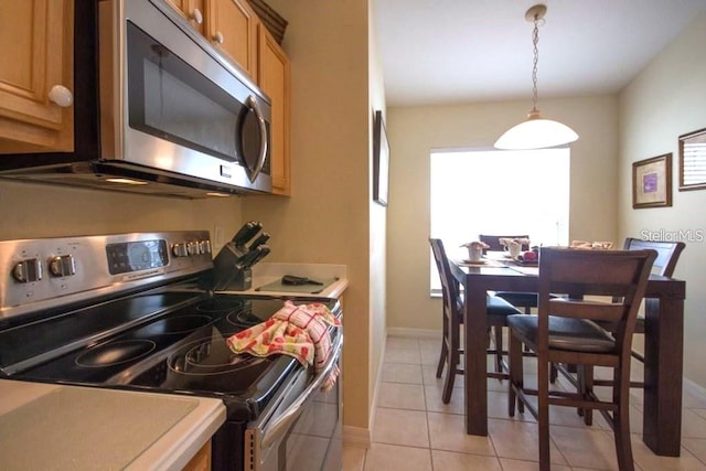 320 Henley Cir, Davenport, FL 33896 - kitchen with appliances with stainless steel finishes, brown cabinetry, light tile patterned flooring, pendant lighting, and light countertops