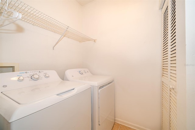 laundry room with washer and dryer and light tile patterned floors