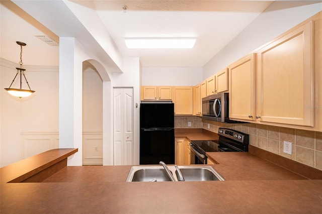 kitchen featuring pendant lighting, sink, black fridge, light brown cabinets, and electric stove