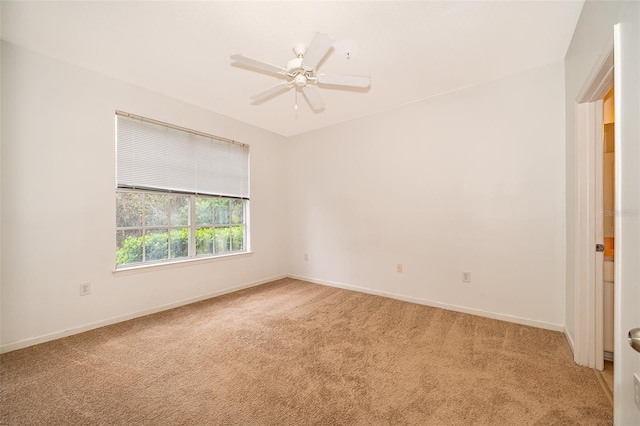 carpeted spare room featuring ceiling fan