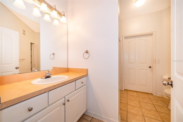 bathroom with vanity, toilet, tile patterned flooring, and a notable chandelier