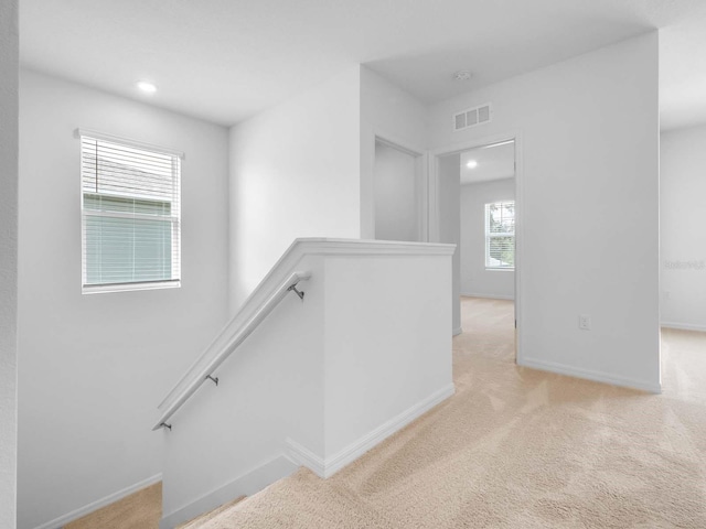 hall featuring light colored carpet