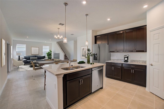 kitchen with sink, stainless steel appliances, a kitchen island with sink, and dark brown cabinetry