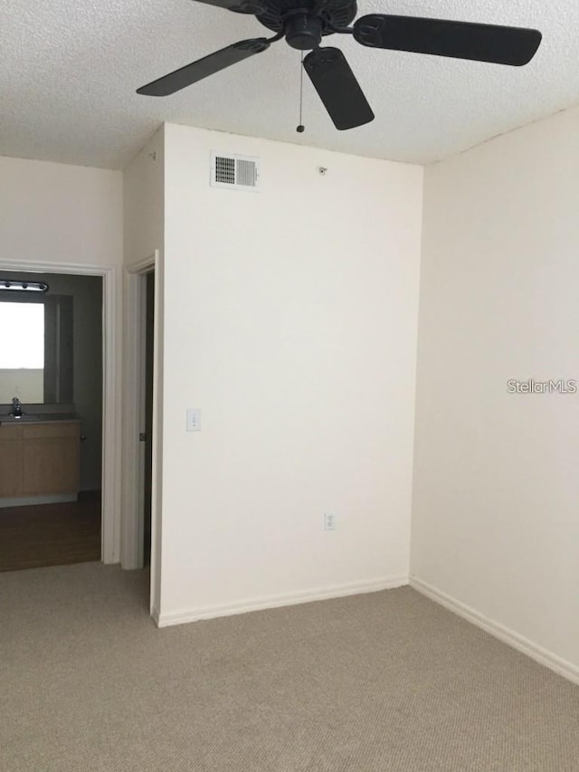 unfurnished room featuring ceiling fan, carpet, and a textured ceiling