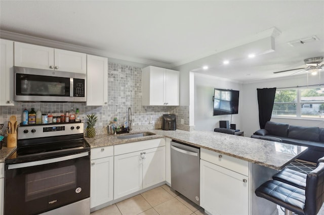 kitchen featuring sink, kitchen peninsula, appliances with stainless steel finishes, and ceiling fan