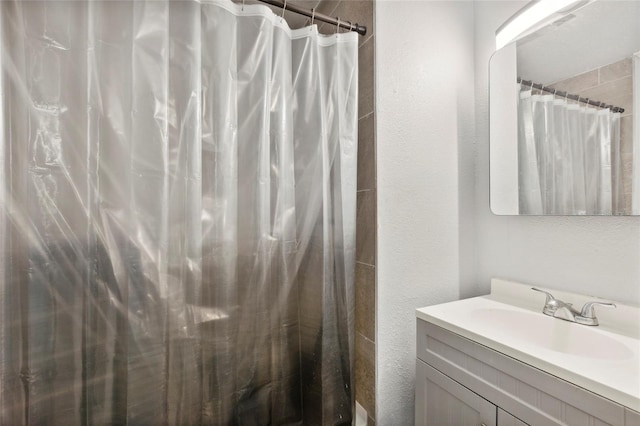 bathroom featuring a shower with shower curtain and vanity