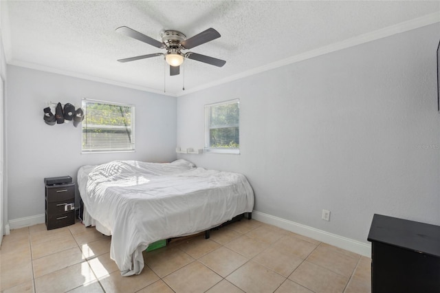 bedroom featuring ceiling fan, ornamental molding, a textured ceiling, and light tile patterned floors