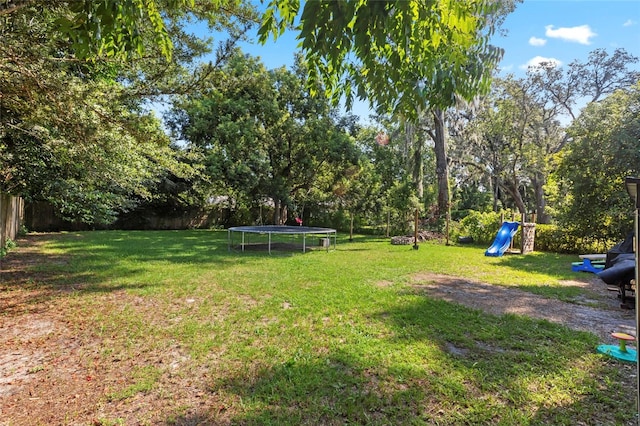 view of yard with a playground and a trampoline