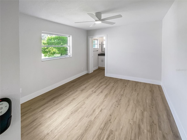 unfurnished room with light wood-style floors, ceiling fan, and baseboards