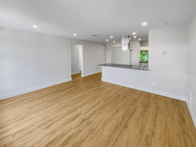 unfurnished living room with baseboards, visible vents, light wood-style flooring, and recessed lighting