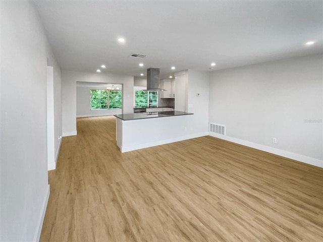 unfurnished living room with light wood-style floors, recessed lighting, visible vents, and baseboards