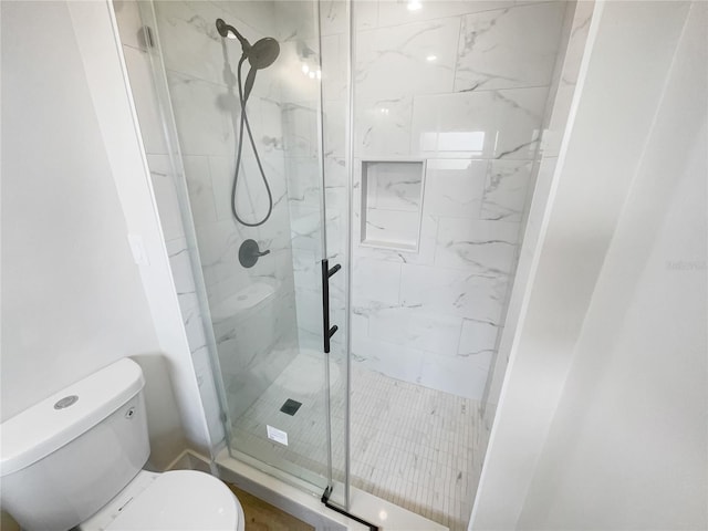 bathroom with toilet and a shower stall