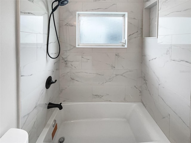 bathroom featuring bathtub / shower combination and toilet