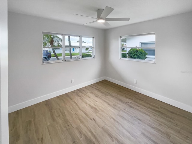 unfurnished room featuring a ceiling fan, baseboards, and wood finished floors