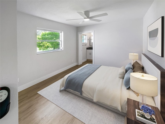 bedroom with ceiling fan, ensuite bathroom, wood finished floors, and baseboards