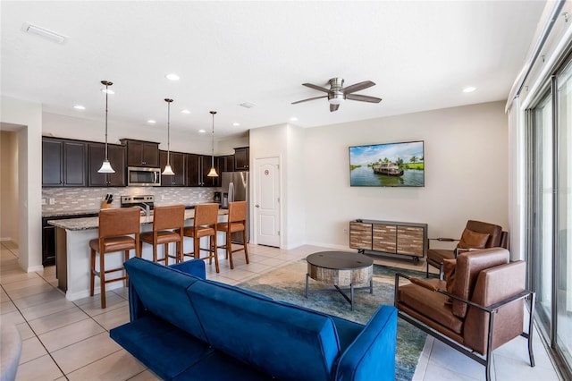 living area with recessed lighting, baseboards, a ceiling fan, and light tile patterned flooring