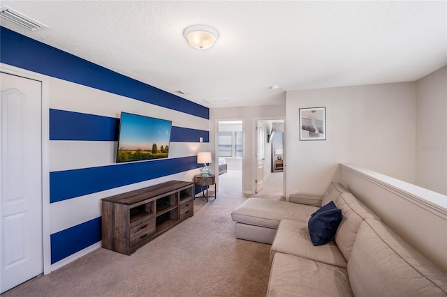 living room featuring light colored carpet, visible vents, and a textured ceiling