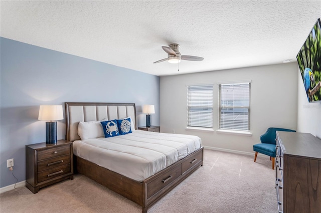 bedroom with baseboards, a textured ceiling, and light colored carpet