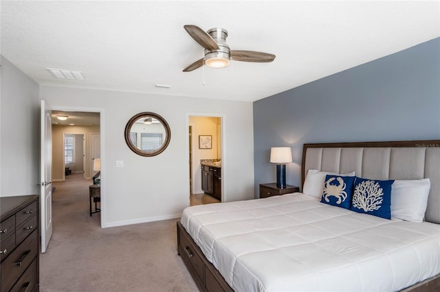 bedroom featuring light carpet, baseboards, visible vents, ceiling fan, and ensuite bathroom