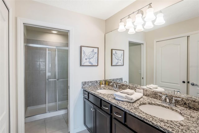 full bathroom with a sink, a shower stall, and double vanity